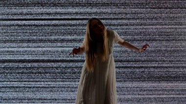 Cadılar Bayramı korku filmi yaratıcı konsepti. Siluet dijital televizyon ekranına karşı. Büyük dijital ekranın önünde beyaz sesli zombi gibi poz veren ürkünç kadın..