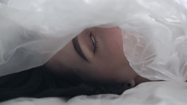 ボディビューティーとファッション広告 半透明なオイルクロスで部分的に覆われた女性の顔と目を閉じる — ストック動画