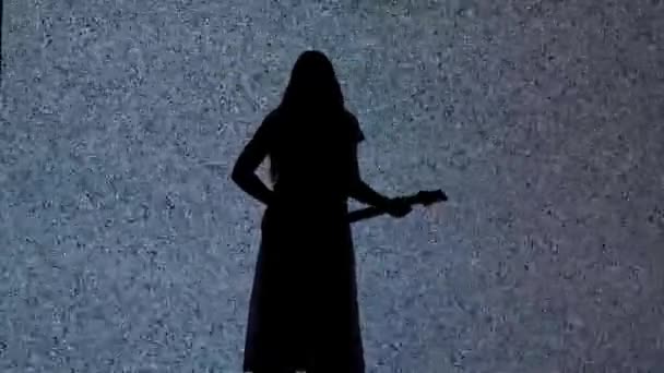 万圣节恐怖电影创意的概念 数码电视屏幕上的轮廓 在有白色噪音的大数字屏幕前 穿着在吉它上弹奏的女主角形象 — 图库视频影像