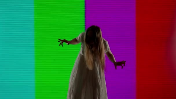 ハロウィンホラー映画クリエイティブコンセプト デジタルテレビ画面に対するシルエット スリラーのシーン 信号なしで大きなデジタル スクリーンの前にゾンビのようにポーズするドレスの不気味な女性 — ストック動画