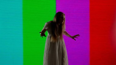 Cadılar Bayramı korku filmi yaratıcı konsepti. Siluet dijital televizyon ekranına karşı. Sinyal olmadan büyük dijital ekranın önünde zombi gibi poz veren ürkütücü kadın..