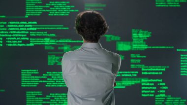 Geleceğin üniversitesi ve yapay zeka konsepti. Büyük dijital ekrana karşı bilişim uzmanı. Arka plan genç mühendis bilim adamı dijital kod yazılım verileri ile ekranın önünde.