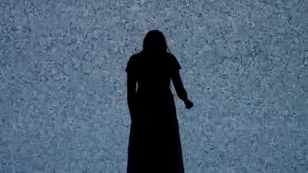 ハロウィンホラー映画クリエイティブコンセプト デジタルテレビ画面に対するシルエット スリラーのシーンは白いノイズが付いている大きいデジタル スクリーンの前で歩くナイフが付いている女性を怖がらせました — ストック動画