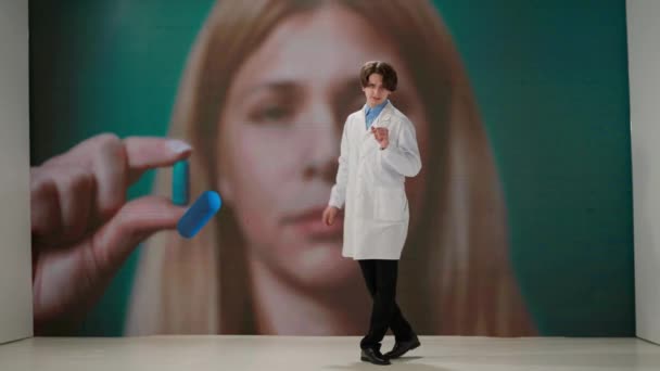 一名身穿白色实验室外套的男性专业人员站在一个巨大的数字屏幕上的药物前 并发表了一篇科学演讲 保健和保健的概念 — 图库视频影像