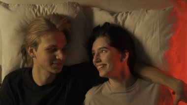 Samimi ilişki kavramını seviyorum. Yatak odasında romantik bir çift manzarası. Erkek ve kadın şehvetli aşıklar yatakta birlikte yatıyor ve gülümsüyor, yakınlık ön sevişme ve bağlanma.