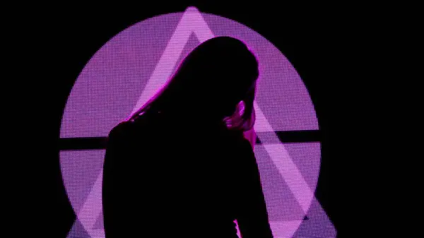 デジタルビジュアルテクノロジーコンセプト デジタル壁に対する女性モデル クラブのネオンシンボルの背景を持つデジタルスクリーンウォールの前に立っている女性のシルエット — ストック写真