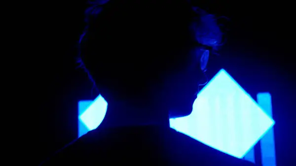 数字视觉技术概念 在黑暗俱乐部里 男性的轮廓紧靠着数字墙 男人站在大的数字屏幕背景上 有霓虹灯的符号 背向拍摄 — 图库照片