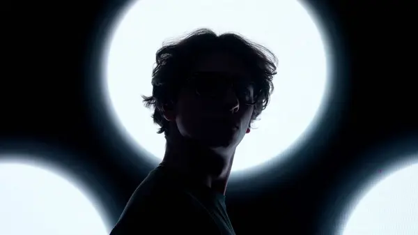 デジタルビジュアルテクノロジーコンセプト 黒いデジタル壁に対する眼鏡の男性 ダーククラブの抽象的なシンボルでデジタルスクリーンウォールの前に立ってショットを閉じる男のシルエット — ストック写真