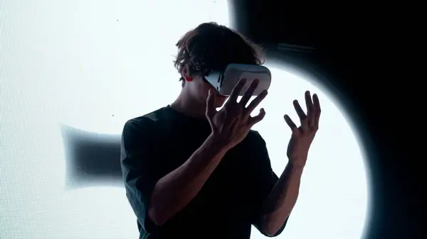 デジタルビジュアルテクノロジーコンセプト デジタルスクリーンの壁の前に立っている仮想現実のガラスの男のシルエットは手を握るまわりを見る抽象的なシンボル — ストック写真