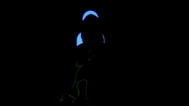 デジタルビジュアルテクノロジーコンセプト 大きなデジタル壁に対する男性 ダーククラブでネオンシンボルを刺すデジタルスクリーンウォールの前にフーディーシルエットの男 ボディ上のレーザー投影 — ストック動画