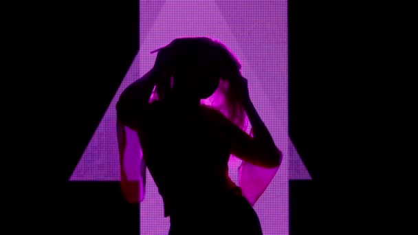 数字视觉技术概念 与数字墙相对立的女性模型 女子轮廓在数字屏幕墙前舞姿 俱乐部背景为霓虹灯抚摸符号 — 图库视频影像