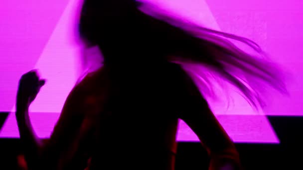 デジタルビジュアルテクノロジーコンセプト デジタル壁に対する女性モデル クラブのバックグラウンドネオンストロブシンボルとデジタルスクリーンウォールの前で踊る女性のシルエット — ストック動画