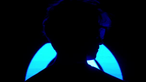デジタルビジュアルテクノロジーコンセプト ダーククラブのデジタル壁に近い男性のシルエット ネオンストロブシンボル バックショットで大きなデジタルスクリーンの背景に向かって立っている男 — ストック動画