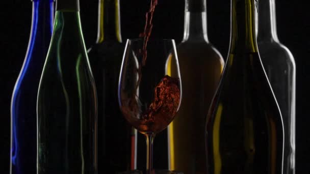 유리에 부어지고 와인의 어두운 배경은 활기찬 와인과 황금색 음색과 대조됩니다 — 비디오