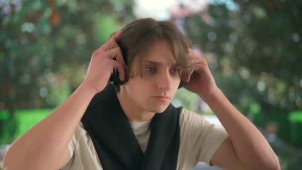 Geniş Kablosuz Kulaklıkla Müzik Dinleyen Genç Bir Adam Bulanık Bir — Stok video