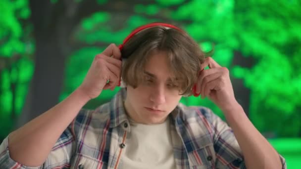 Joven Escuchando Música Grandes Auriculares Inalámbricos Hombre Frente Paisaje Parque — Vídeo de stock