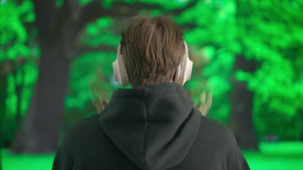 Joven Escuchando Música Grandes Auriculares Inalámbricos Hombre Frente Paisaje Parque — Vídeos de Stock