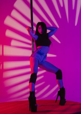 Güzel seksi kadın erotik direk dansı yapıyor. Dansçı kadın stüdyodaki direkte egzotik koreografi yapıyor..