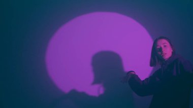 İç ritmini hip hop dansı ile kanalize eden bir kız, renkli spot ışıklarının ışıl ışıl renkleriyle aydınlatılıyor. Her dinamik ve cesur adımın kentsel ifadenin canlı ritmini yansıtmasını izleyin.