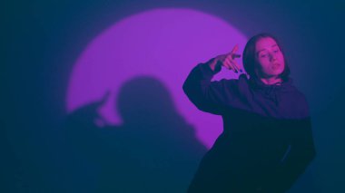 İç ritmini hip hop dansı ile kanalize eden bir kız, renkli spot ışıklarının ışıl ışıl renkleriyle aydınlatılıyor. Her dinamik ve cesur adımın kentsel ifadenin canlı ritmini yansıtmasını izleyin.