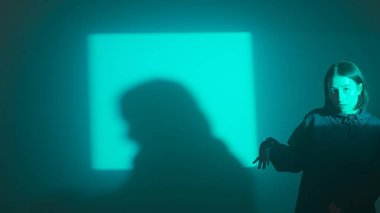 Bir kız dansçı hip hop yapıyor. Solo performans, müzik ve hareket arasındaki güçlü bağlantıyı vurgulayan göz kamaştırıcı çok renkli ışıkların arka planına göre ayarlanır..