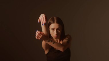 Bir kız dansçı hip hop yapıyor. Solo performans, müzik ve hareket arasındaki güçlü bağlantıyı vurgulayan göz kamaştırıcı çok renkli ışıkların arka planına göre ayarlanır..