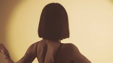 Parlak sarı projektörün arka planında hip-hop yapan kız. Her hareket sokak dansının kalbiyle yankılanır, canlı ambiyansla mükemmel uyum sağlar..