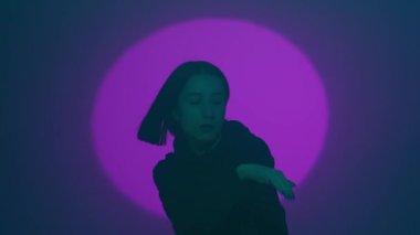İç ritmini hip hop dansı ile kanalize eden bir kız, renkli spot ışıklarının ışıl ışıl renkleriyle aydınlatılıyor. Her dinamik ve cesur adımın kentsel ifadenin canlı ritmini yansıtmasını izleyin.