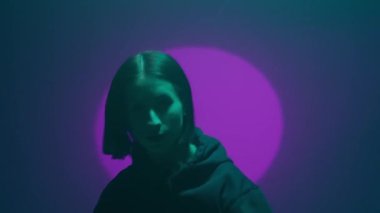 İç ritmini hip hop dansı ile kanalize eden bir kız, renkli spot ışıklarının ışıl ışıl renkleriyle aydınlatılıyor. Her dinamik ve cesur adımın kentsel ifadenin canlı ritmini yansıtmasını izleyin.