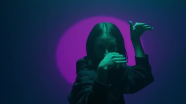 İç ritmini hip hop dansı ile kanalize eden bir kız, renkli spot ışıklarının ışıl ışıl renkleriyle aydınlatılıyor. Her dinamik ve cesur adımın kentsel ifadenin canlı ritmini yansıtmasını izleyin.