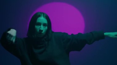 İç ritmini hip hop dansı ile kanalize eden bir kız, renkli spot ışıklarının ışıl ışıl renkleriyle aydınlatılıyor. Her dinamik ve cesur adımın kentsel ifadenin canlı ritmini yansıtmasını izleyin.