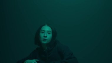 İç ritmini hip hop dansı ile kanalize eden bir kız, renkli spot ışıklarının ışıl ışıl renkleriyle aydınlatılıyor. Her dinamik ve cesur adımın kentsel ifadenin canlı ritmini yansıtmasını izleyin.