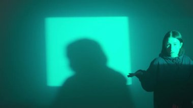 Bir kız dansçı hip hop yapıyor. Solo performans, müzik ve hareket arasındaki güçlü bağlantıyı vurgulayan göz kamaştırıcı çok renkli ışıkların arka planına göre ayarlanır..