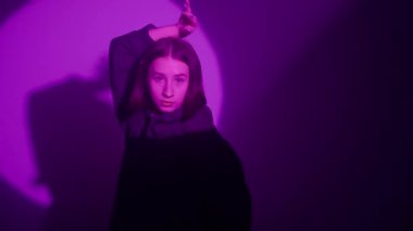 İç ritmini hip hop dansı ile kanalize eden bir kız, renkli spot ışıklarının ışıl ışıl renkleriyle aydınlatılıyor. Her dinamik ve cesur adımın kentsel ifadenin canlı ritmini yansıtmasını izleyin.