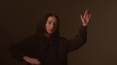 Bir kız dansçı hip hop yapıyor. Solo performans, müzik ve hareket arasındaki güçlü bağlantıyı vurgulayan göz kamaştırıcı çok renkli ışıkların arka planına göre ayarlanır..