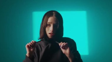 Bir kız dansçı hip hop yapıyor. Solo performans, müzik ve hareket arasındaki güçlü bağlantıyı vurgulayan göz kamaştırıcı çok renkli ışıkların arka planına göre ayarlanır..