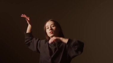 Bir kız dansçı hip hop yapıyor. Solo performans, müzik ve hareket arasındaki güçlü bağlantıyı vurgulayan göz kamaştırıcı çok renkli ışıkların arka planına göre ayarlanır..