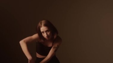 Bir kız dansçı hip hop yapıyor. Solo performans, müzik ve hareket arasındaki güçlü bağlantıyı vurgulayan göz kamaştırıcı çok renkli ışıkların arka planına göre ayarlanır..