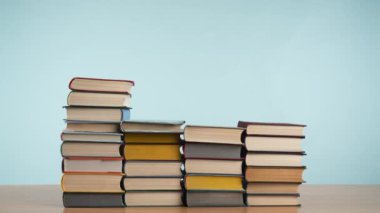 Stop Motion video, her kitap kaybolmadan önce, ahşap bir yüzey üzerine inşa canlı kapaklı eski kitap yığınları gibi sakin bir mavi arka plan,.