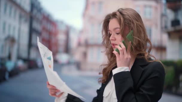 ガジェットと現代の日常生活広告コンセプト 毎日スマートフォンを使っている女性 スマートフォンで話す紙文書を持っている若いビジネス女性 外出中の問題を論じる — ストック動画