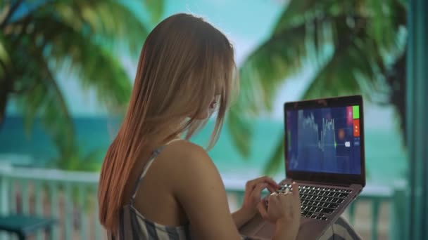 自由职业和自营职业生活方式的概念 从事远距离工作和旅行的女性 热带海滩度假胜地的女自由职业者在笔记本电脑上工作 一边用耳机听音乐 一边向后射击 — 图库视频影像