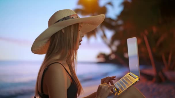 フリーランスと自営業ライフスタイルのコンセプト 遠くから働き 旅をする女性 サンセットのトロピカルビーチに座って ラップトップを持ち 働いている若い女性フリーランサー — ストック動画