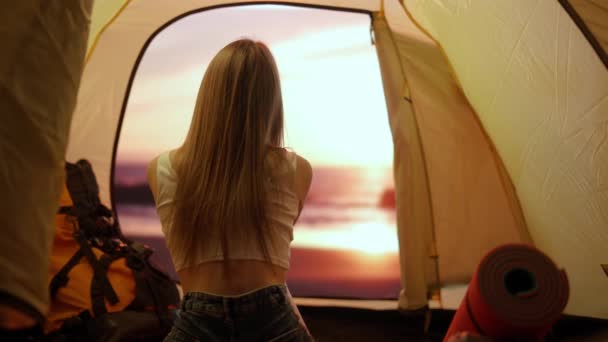 キャンプと冒険のコンセプト キャンプ場の旅行やハイキング 自然を探検する人 外を見るビーチの日没のテントの内側に座っている若い女性 休日と屋外での休暇 — ストック動画