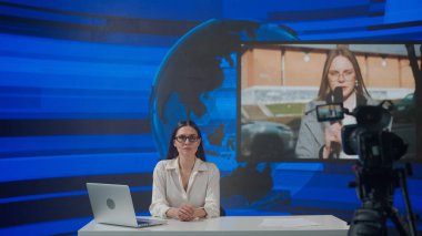 Canlı TV haber yayın konsepti. Stüdyodaki bayan sunucu. Kadın sunucu masa başında oturmuş günlük olayları sunuyor, dışarıda muhabirlerle konuşuyor, arka planda son dakika haberleri veriyor..