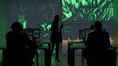 Proje yöneticisi bilgisayar bilimi konsepti. Teknik destek ekibi kontrol odasında. Güvenlik ofisindeki bilişim uzmanları, büyük dijital ekran, bilgi ağı verilerinin izlendiğini gösteriyor.