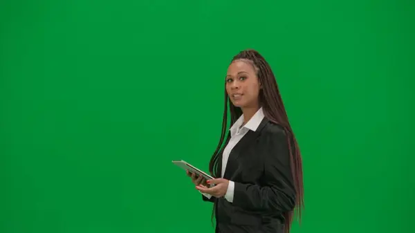 テレビニュースレポートライブ放送広告コンセプト クロマキーの緑色の背景で隔離された女性の記者は アフリカ系アメリカ人女性のニュースホストがタブレットで話すショーは空の領域を示しています — ストック写真
