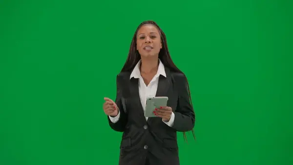 テレビニュースレポートとライブ放送広告コンセプト クロマキーの緑色の背景で隔離された女性の記者は アフリカ系アメリカ人女性のニュースホストが歩き タブレットを保持 — ストック写真