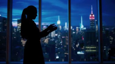 Şirket reklam konsepti. Ofiste başarılı bir iş kadını. Kadın ceo hedge fonu yöneticisi pencerenin önünde akşam manzaralı tablet üzerinde çalışıyor.