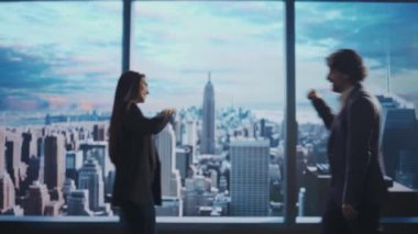 Şirket reklam konsepti. Ofiste başarılı iş adamları. Kadın ve erkek, üst düzey yatırım fonu yöneticisi sabah manzaralı pencerenin önünde yumruk tokuşturuyor..