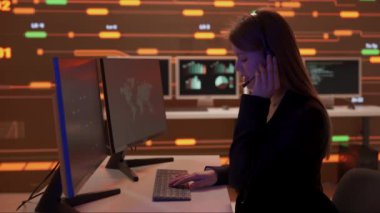 Proje yöneticisi bilgisayar bilimi konsepti. Kontrol odasında teknik destek. Kulaklık konusunda kadın bilişim uzmanları bilgisayarlar üzerinde çalışıyor, büyük dijital ekran altyapısı bilgi ağı verilerini izliyor.